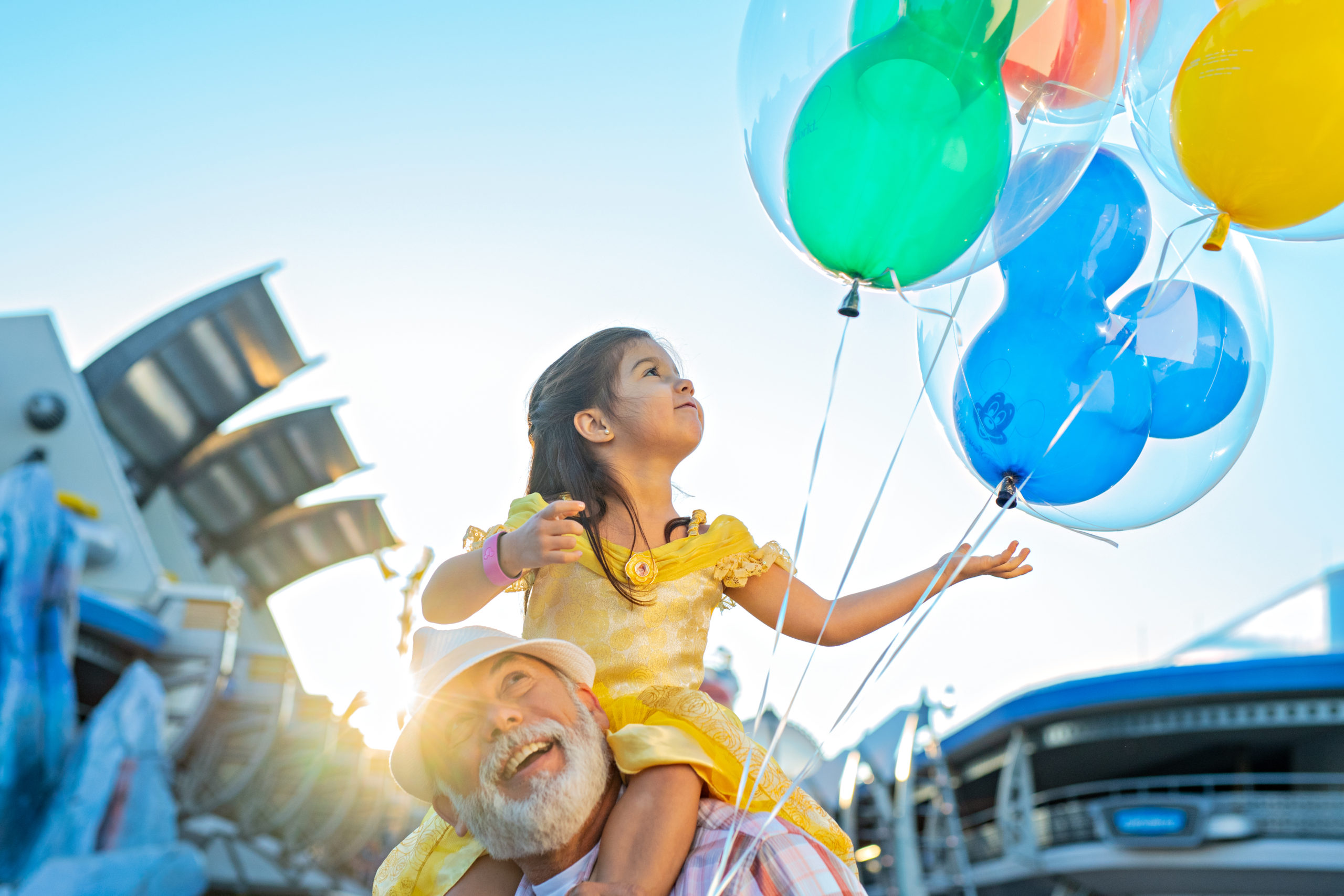 Little girl holding Disney balloons